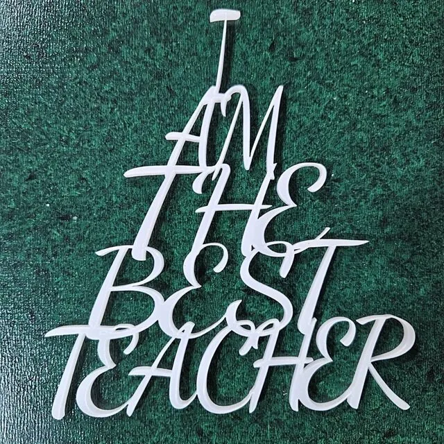 Laser-cut stacked text design saying 'I Am The Best Teacher' in triangle shape, crafted from semi-translucent acrylic and decorative plywood.